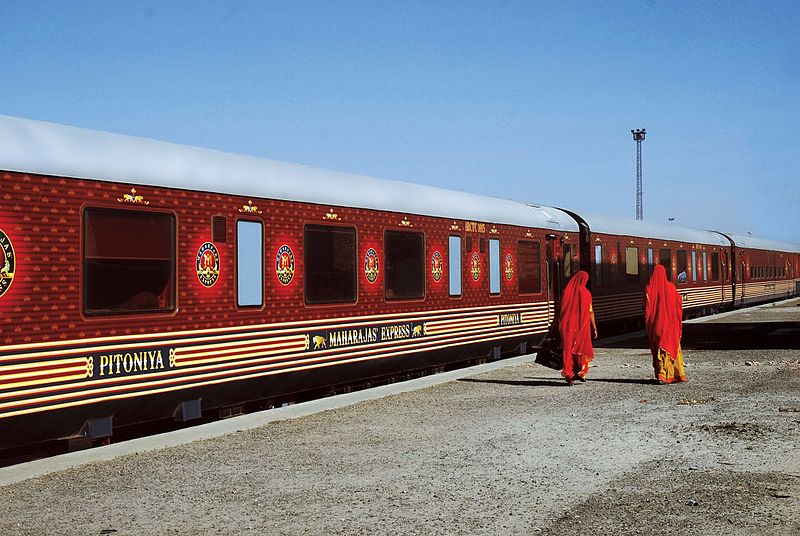 The Maharajas Express halted at a railway station with two ladies passing by