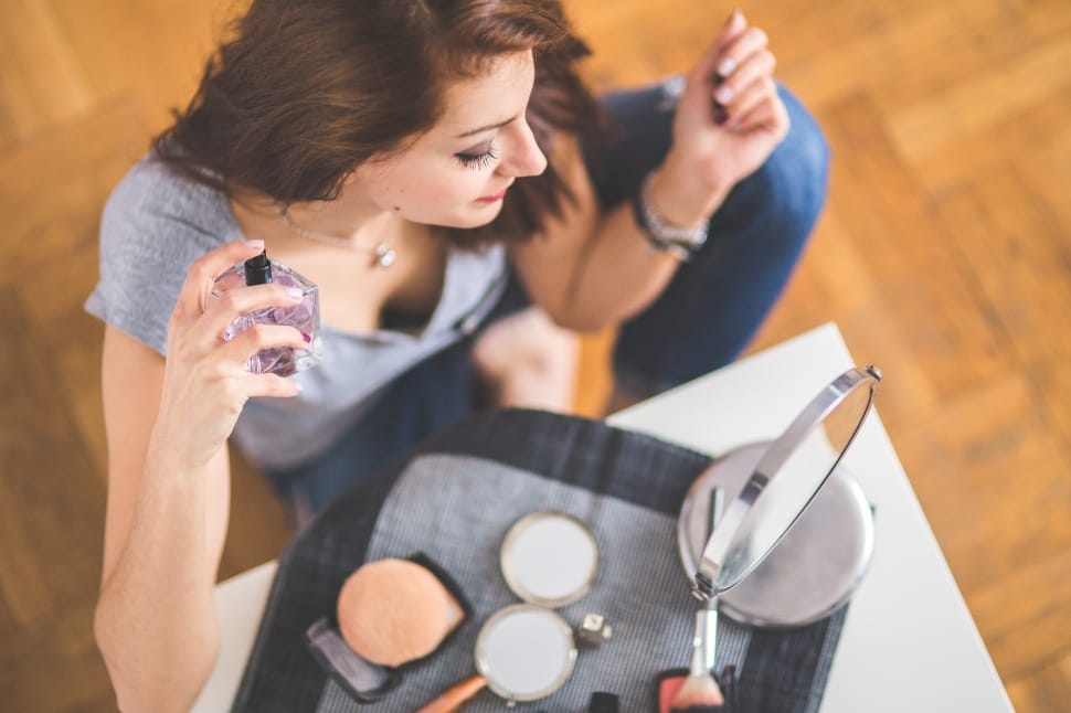 A woman applying makeup in front of a mirror