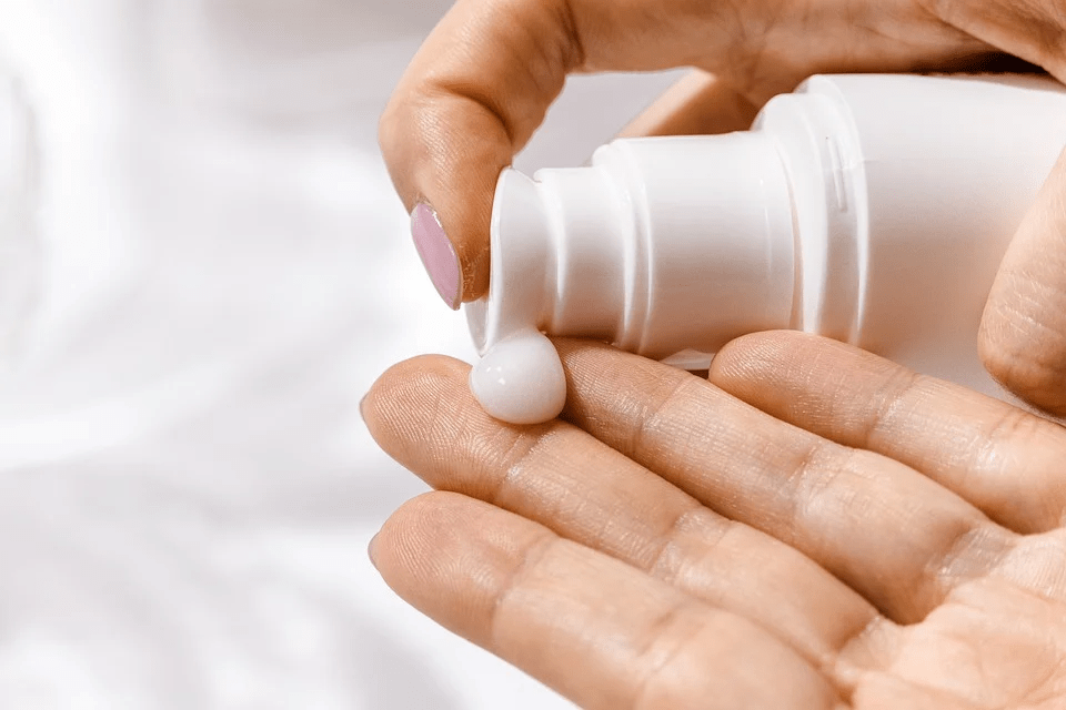 person putting some moisturizer on hand