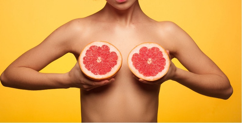 woman holding grapefruit