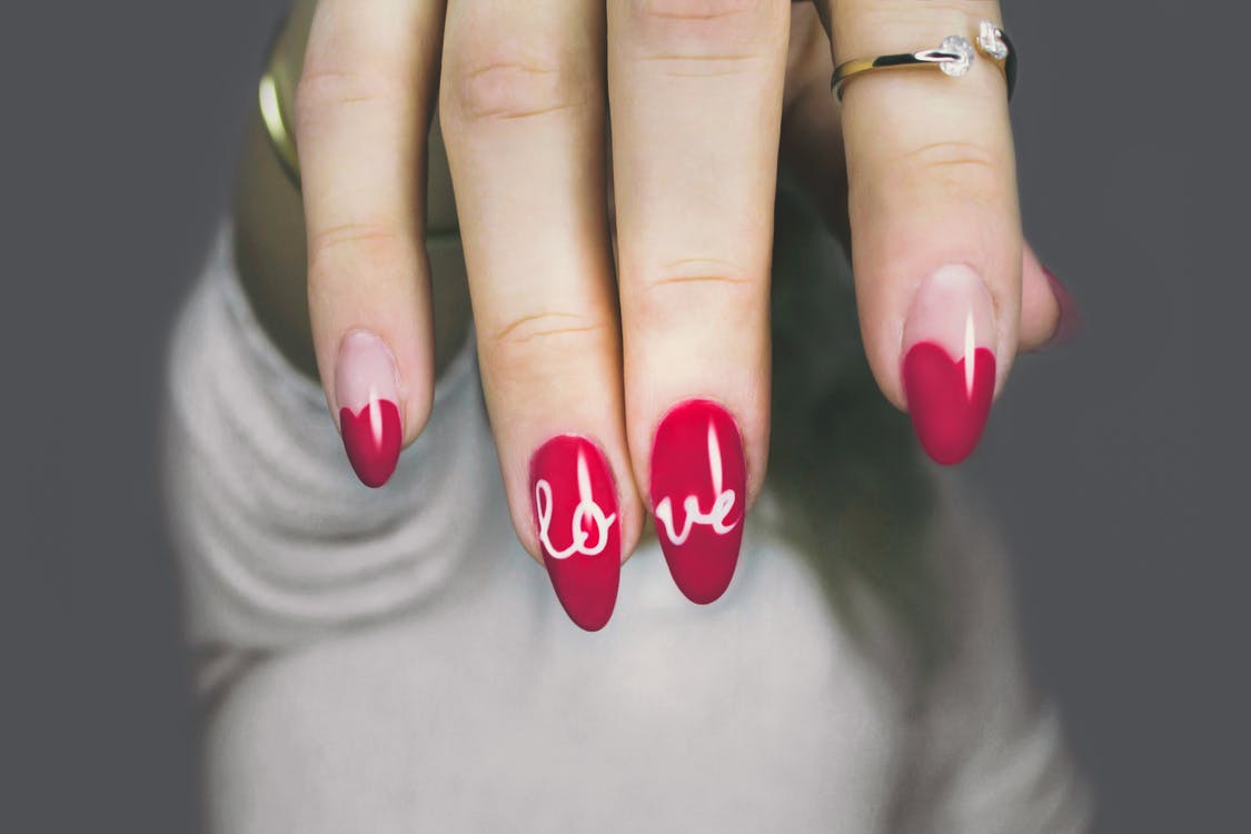 a hand showing red and white manicured nails