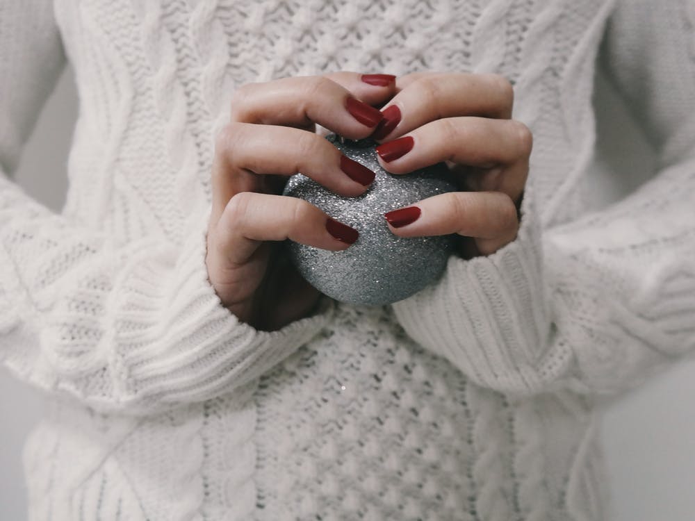 red nail paint holding a grey ball