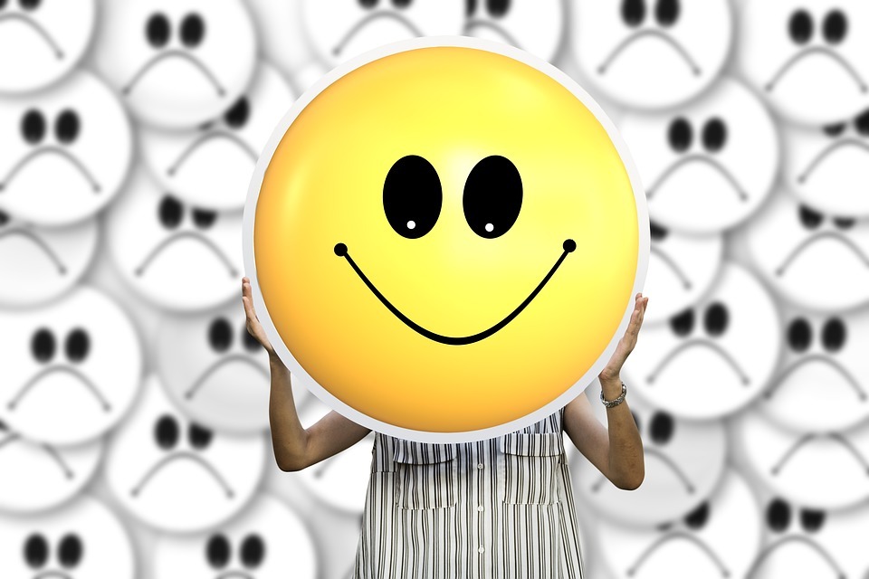 A woman holding a big smiley face