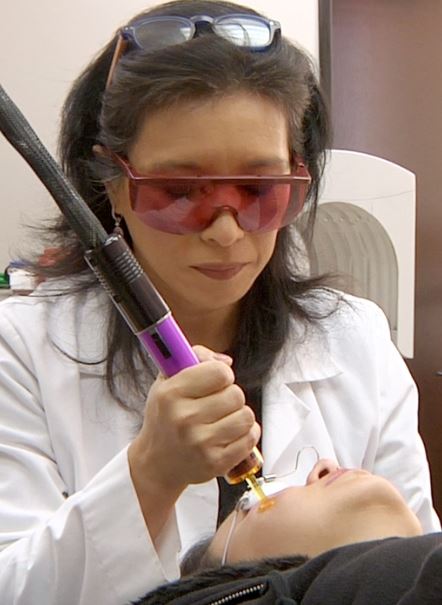 a doctor performing hyperpigmentation treatment with a laser