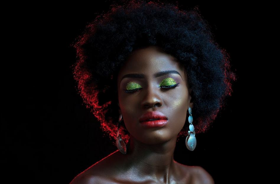 a black woman with makeup closing her eyes