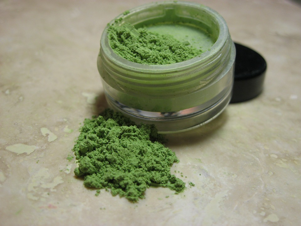 a jar of green color correction powder 